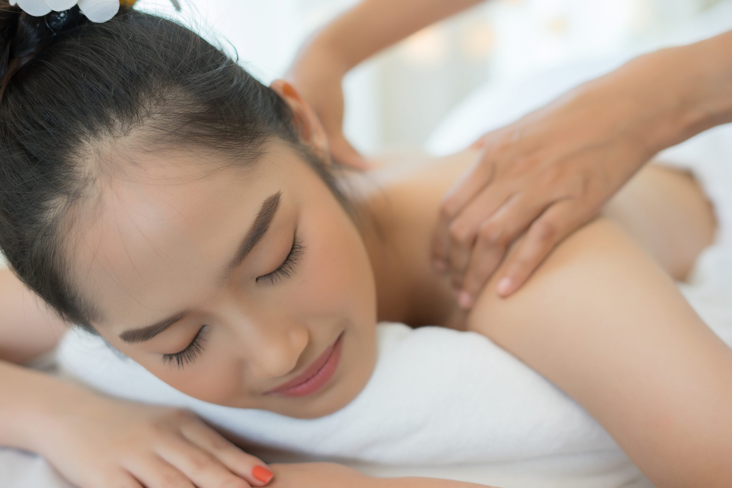 young beautiful woman relaxing during massage in spa salon.